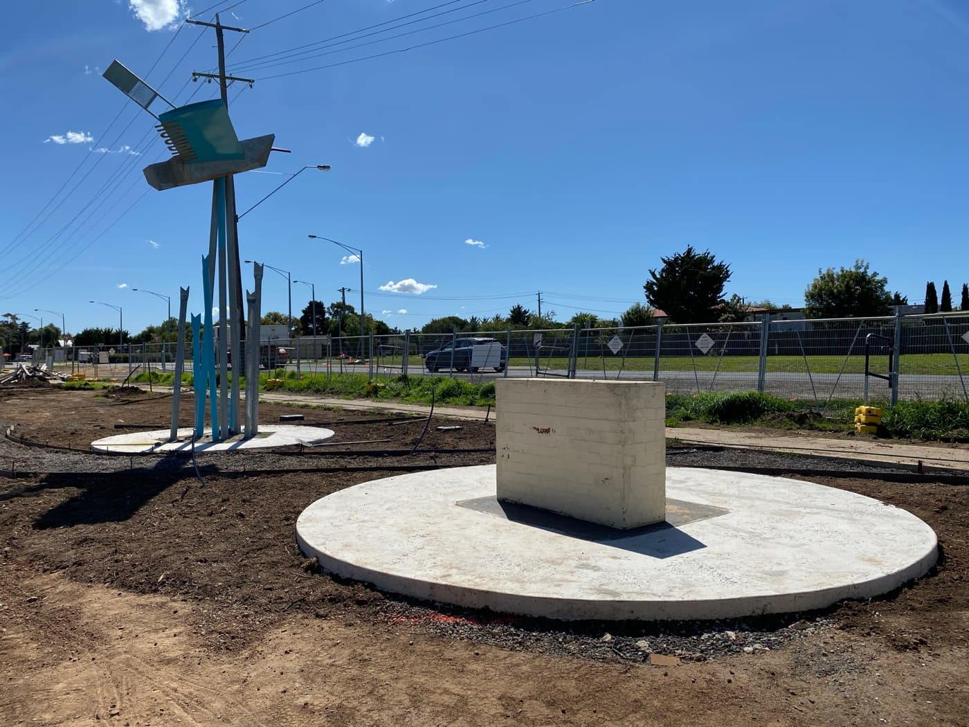 Finished radial concrete slab with central plinth and park sculpture